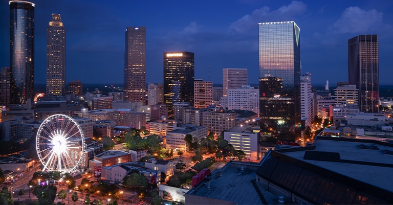 Top Trade Show Cities in the US: The Ultimate List 7 Atlanta skyline at night with illuminated skyscrapers and the glowing SkyView Ferris wheel in the foreground.