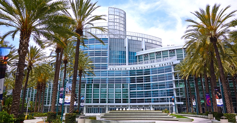 Top Trade Show Cities in the US: The Ultimate List 8 The Anaheim Convention Center surrounded by tall palm trees under a partly cloudy sky.