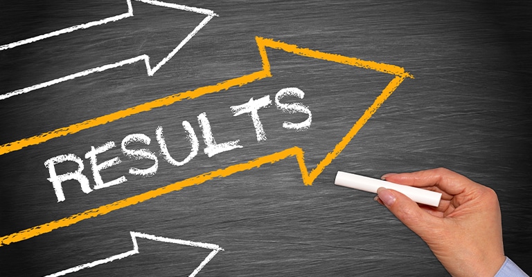 Trade Show Booth Activation: How to Make it All Work 5 Hand drawing an arrow labeled 'RESULTS' on a chalkboard, symbolizing progress and achievement.